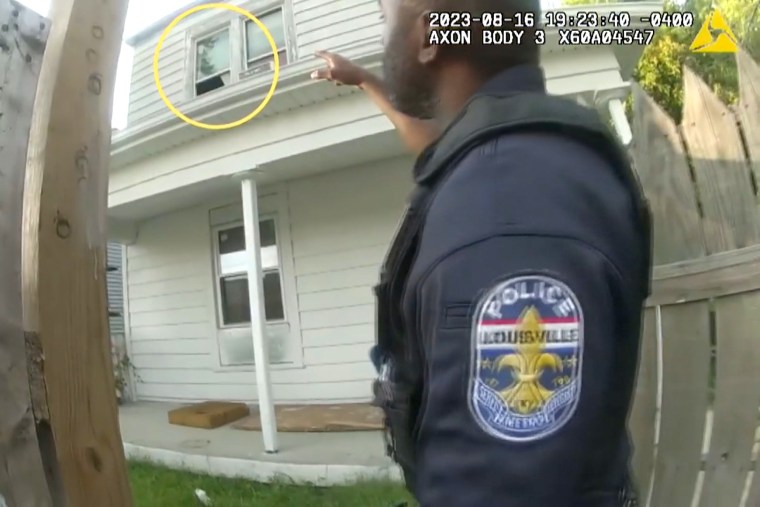 A Louisville police officer points to a window where he and other officers later found a woman in distress on August 16, 2023.