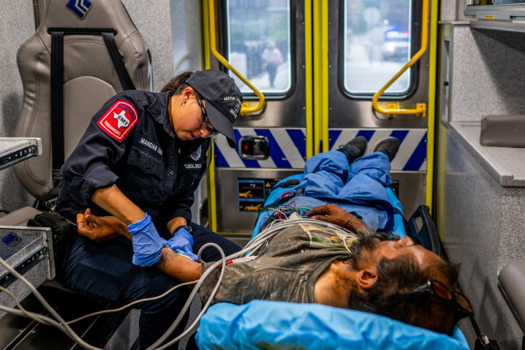 An Austin Travis County medic assists a patient who was found passed out and dehydrated in Austin, Texas, on Aug. 8, 2023.