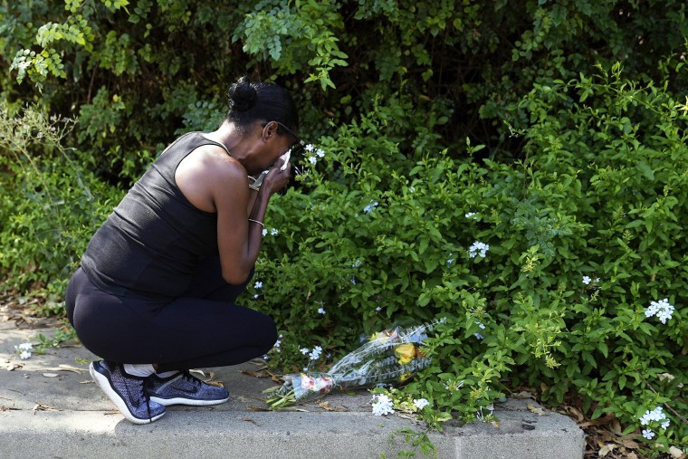 Lisa, only first name given, grieves after placing flowers near the scene of a mass shooting at Cook's Corner, a biker bar in rural Trabuco Canyon, Calif., Thursday, Aug. 24, 2023.