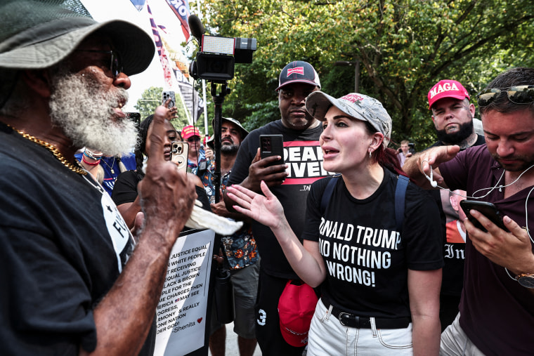 Laura Loomer, far-right activist, speaks with anti-Trump demonstrators near the entrance of the Fulton County Jail, as former President Donald Trump is expected to turn himself in to be processed after his Georgia indictment, in Atlanta on Aug. 24, 2023.