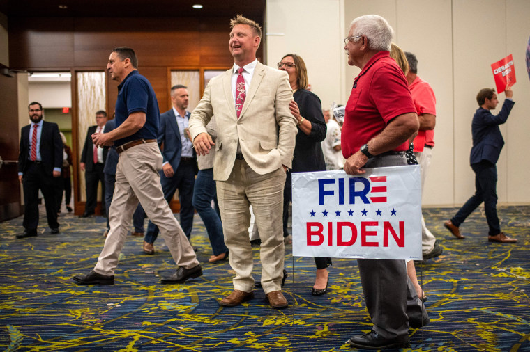 An attendee holds a "Fire Biden" sign at the Republican Party of Iowa's 2023 Lincoln Dinner at the Iowa Events Center in Des Moines, Iowa, on July 28, 2023.