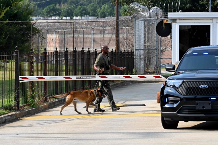 Image: A police officer and K-9 outside of the Fulton County Jail in Atlanta on Thursday. Former President Donald Trump is scheduled to arrive at the jail to surrender this evening.