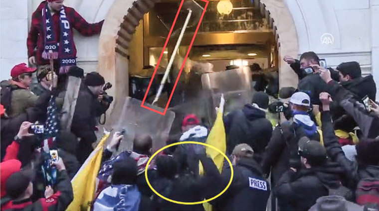 Curtis Logan Tate throwing a floor lamp, surrounded in red, at police officers at the U.S. Capitol on Jan. 6, 2021.