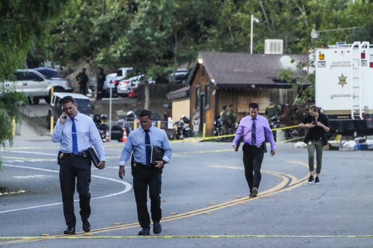Image: Detectives walk at the scene of a mass shooting at Cook's Corner, on Aug. 24, 2023, in Trabuco Canyon, Calif.