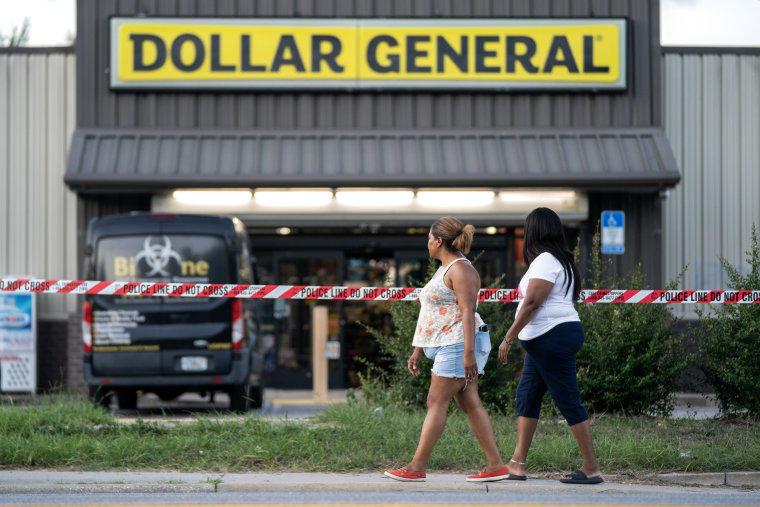 People walk past the Dollar General store where three people were shot and killed the day before  in Jacksonville, Fla. on Aug. 27, 2023.  Police say that the attack by a gunman on Black customers at the store that killed three is being investigated as a hate crime.