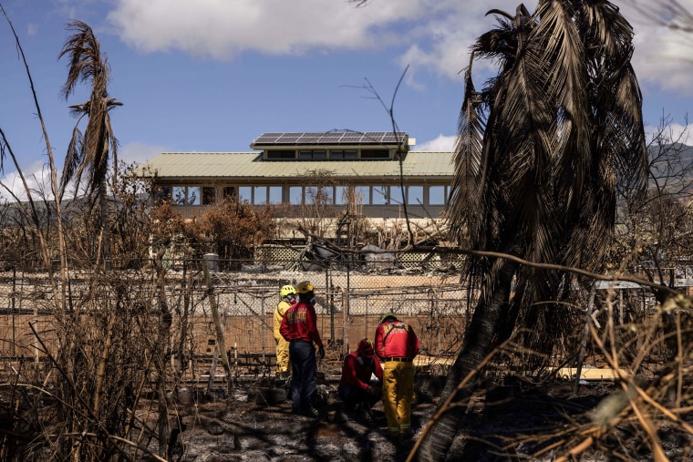Search and recovery team members check charred buildings and cars in the aftermath of the Maui wildfires in Lahaina, Hawaii, on Aug. 18, 2023. 