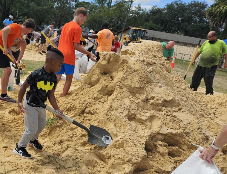 Elonda McNish's son, Omaree James, 4, helps fill sandbags in Gainesville.