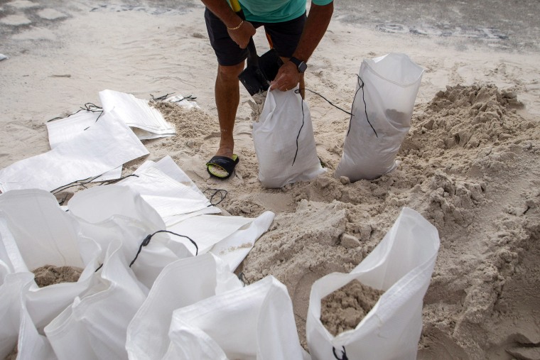 A resident fills sandbags to ward off flooding in St. Petersburg, Fla., on Aug. 28, 2023.
