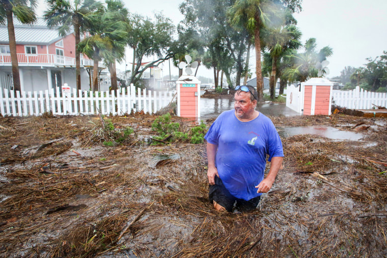 Daniel Dickert wades through floodwaters in front of his home from the Steinhatchee River on Aug 30, 2023, in Florida's Big Bend area. 