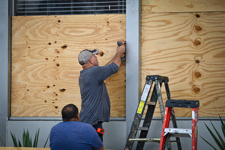 People board up a window in Tampa, Florida, on Aug. 29, 2023, as the city prepares for Hurricane Idalia. 