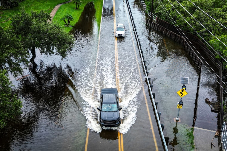 Image: Vehicles attempt to travel on a flooded road in Tampa, Fla., on Aug. 30, 2023, after Hurricane Idalia made landfall.