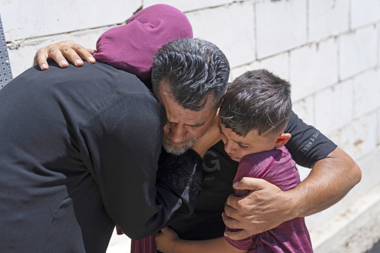 Mourners hug while crying during a funeral for Qusai Matan