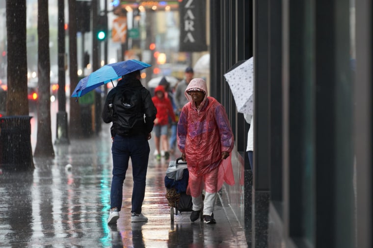 Persona bajo la lluvia en el Hollywood Boulevard, en Los Ángeles, California, el 20 de agosto de 2023.
