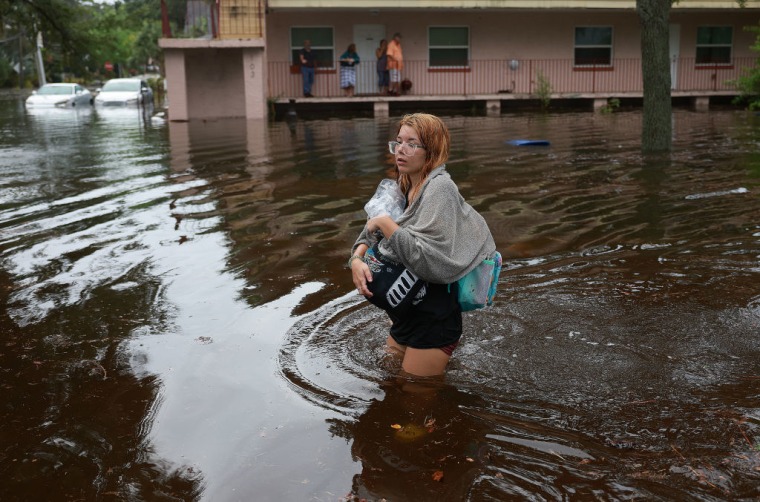 Makatla Ritchter camina por el agua después de evacuar su casa en Tarpon Springs, Florida, tras la llegada del huracán Idalia.