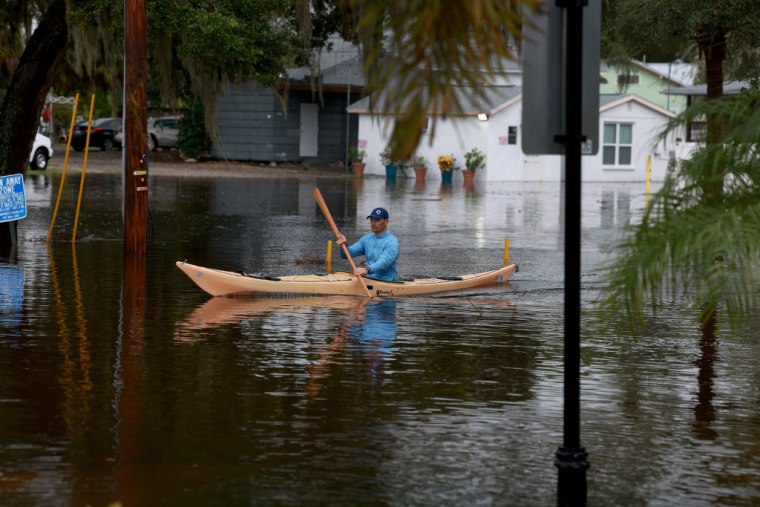 Las personas cruzaron a pie, en canoas o tablas de surf las zonas inundadas en Tarpon Springs, Florida. 