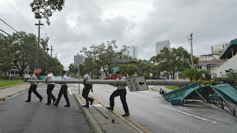 Miembros del Departamento de Bomberos de Tampa retiran un poste de la calle luego de que los vientos provocados por Idalia derribaran a su paso varias estructuras en esa ciudad de Florida.