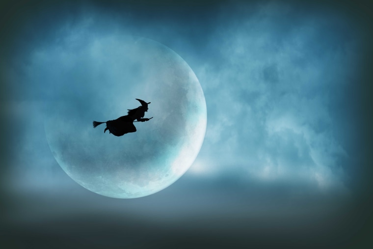 Flying Halloween Witch Silhouetted In Front of Large Moon