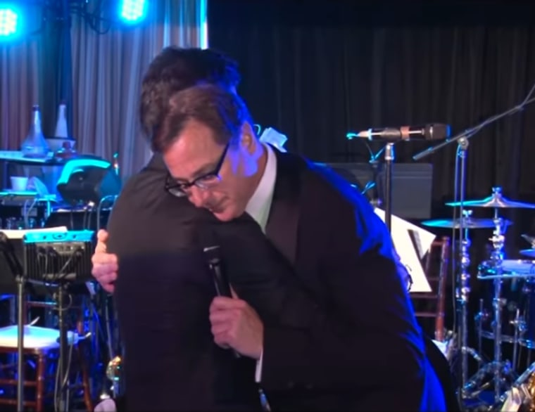 John Stamos and Bob Saget share a hug.