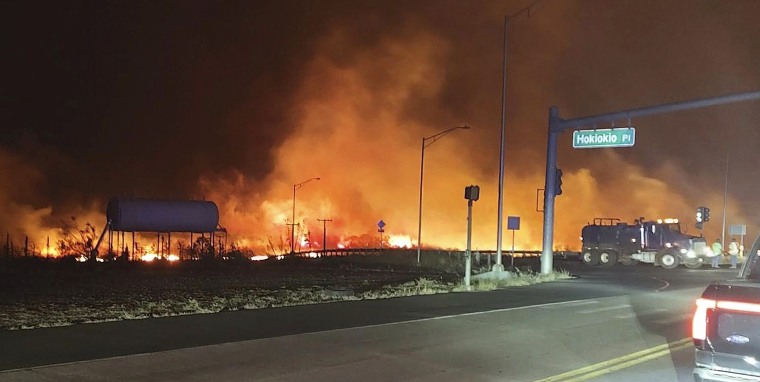 Shows fire and smoke filling the sky from wildfires on the intersection at Hokiokio Place and Lahaina Bypass in Maui, Hawaii 