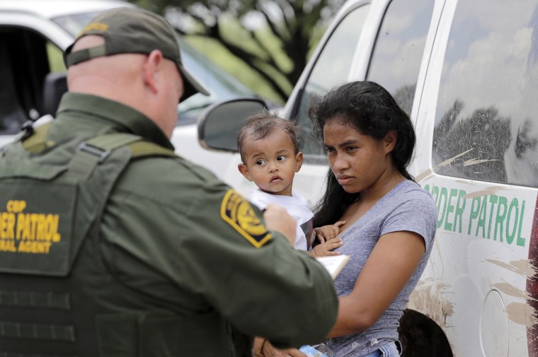 Una mujer proveniente de Honduras se entregaba, junto con su hijo, a un agente de la Patrulla Fronteriza en una zona cercana a McAllen, Texas, el 25 de junio de 2023.