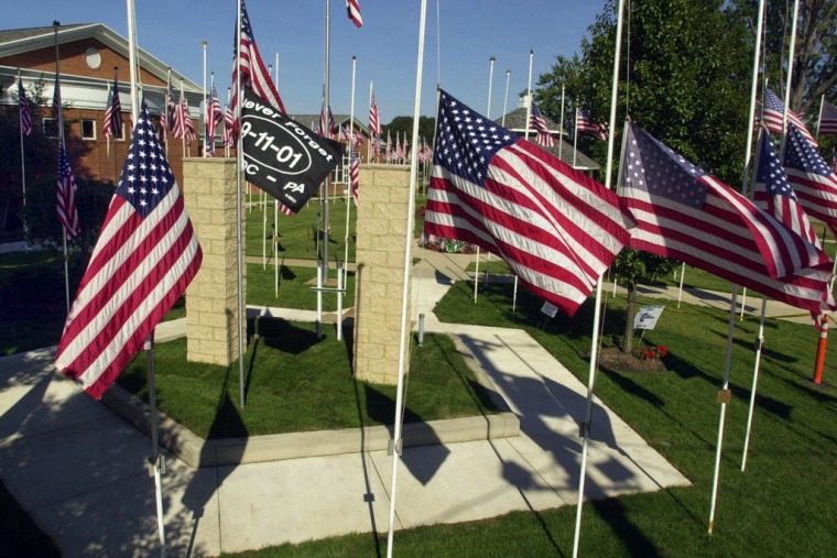 Cientos de banderas estadounidenses rodean un monumento en memoria de las víctimas de los atentados terroristas del 11 de septiembre, detrás del ayuntamiento de Eastlake, Ohio.