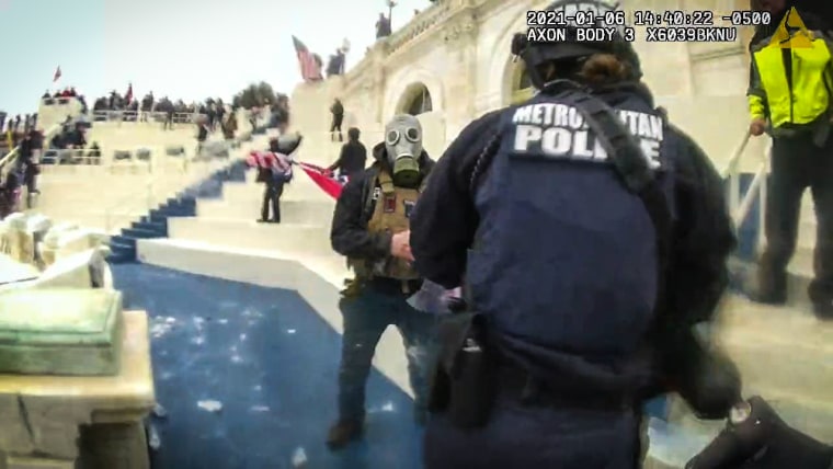 A man in a gas mask faces off with police on Jan. 6 2021 at the U.S. Capitol.