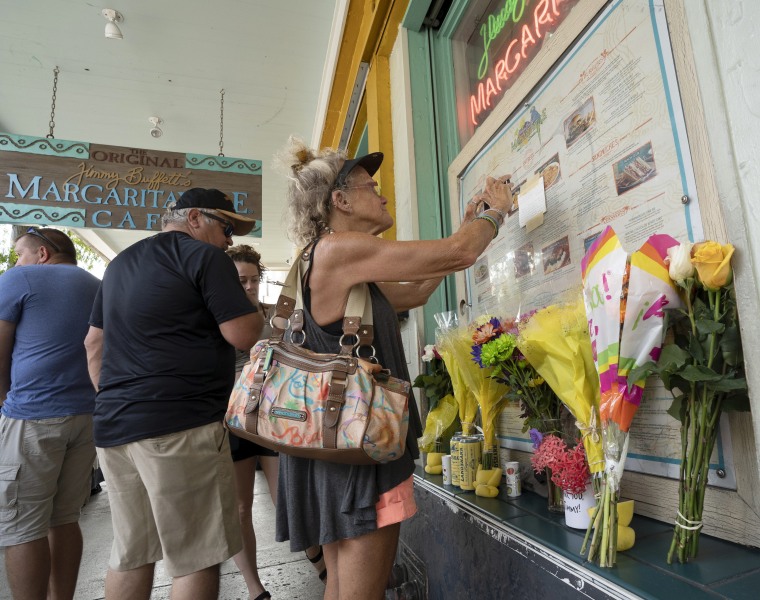 Susan Hudnall pins a condolence note about Jimmy Buffett to the front window of the Margaritaville Cafe in Key West, Fla., Saturday, Sept. 2, 2023, in Key West, Fla. 