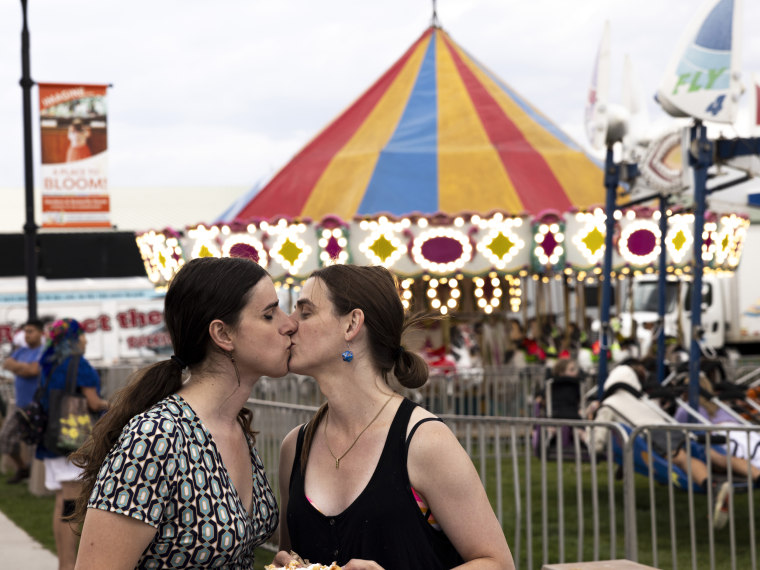 Rep. Zooey Zephyr and her fiancée Erin Reed kiss in between funnel cake at the Western Montana Fair in Missoula, Mont., on Aug. 9, 2023.