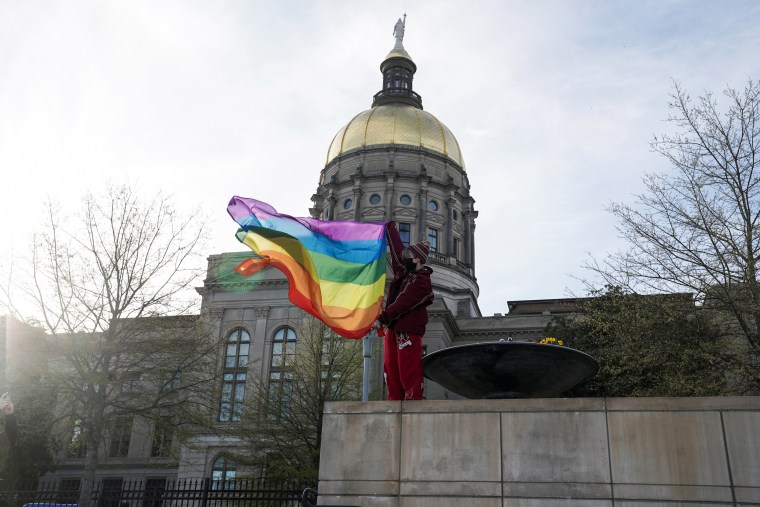 A demonstrator holds a Pride flag outside the Capitol in Atlanta to protest legislation that would prohibit most medical treatments to minors that help affirm gender identity on March 20, 2023.