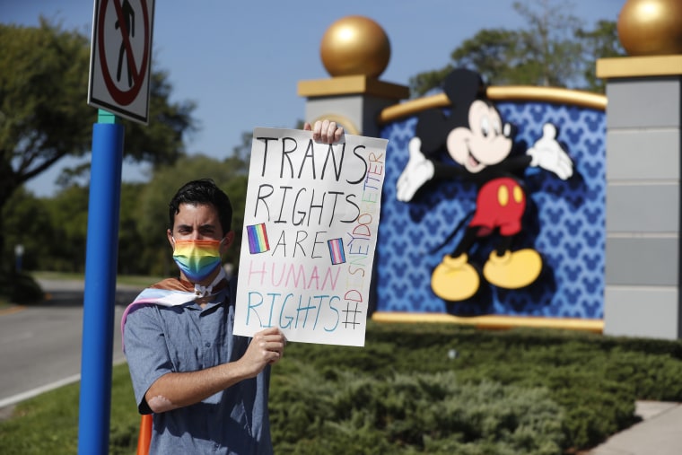 Disney employee Nicholas Maldonado holds a sign while protesting outside of Walt Disney World in Orlando, Fla.