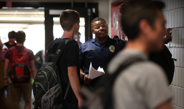 A school resource officer at Highland Park High School in St. Paul, Minn., with students at the end of a school day in 2016. 