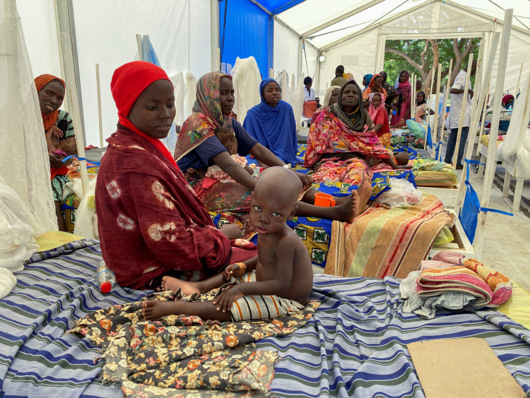 Patients sit on the beds at a makeshift MSF hospital