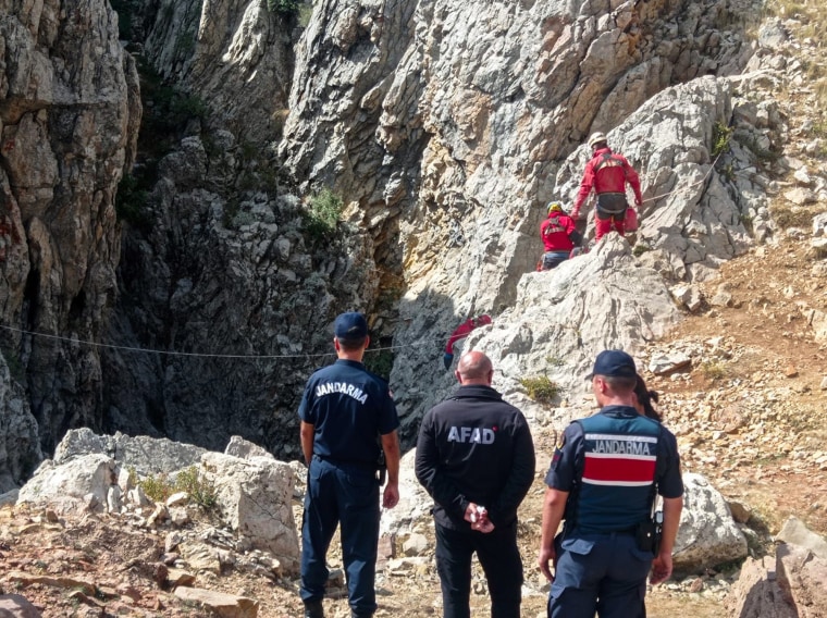 European Cave Rescue Association members and Turkish gendarmerie officers stand next to the entrance to Morca cave in southern Turkey, Thursday, Sept. 7, 2023, where an effort is under way to rescue an ill American caver. 