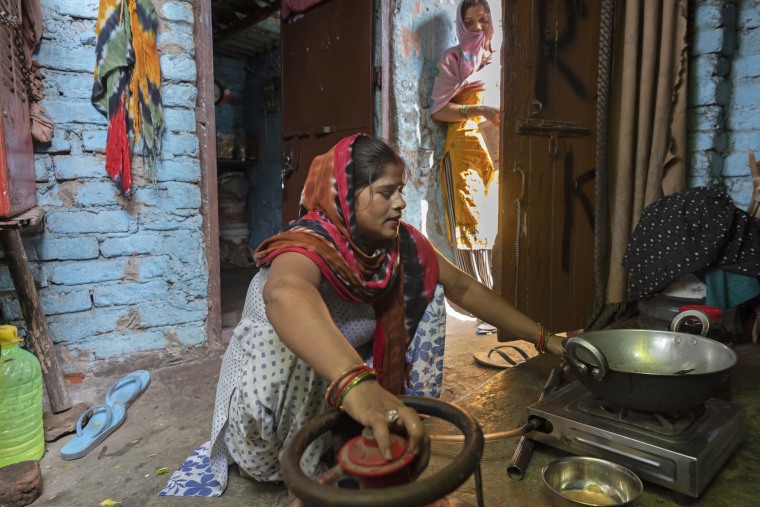 Raj Kumari prepares a meal at her home in New Delhi.