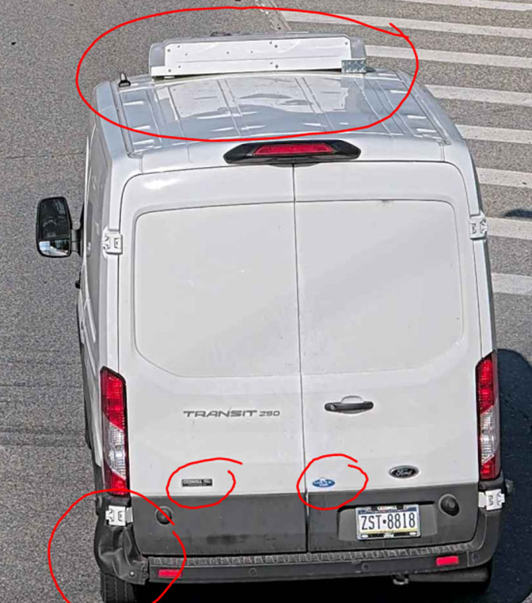 Image of white van with cooling unit and damaged fender. 