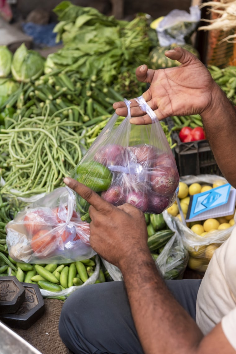 Vendor selling bags in a street market, New Delhi, India Stock