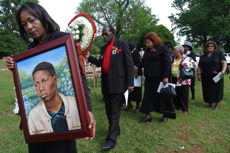 Shirley Peoples carries a portrait of Johnnie Robinson and leads a procession of family and others during a wreath laying ceremony in memory of Robinson on May 5, 2007, at New Grace Hill Cemetery in Birmingham, Ala. 