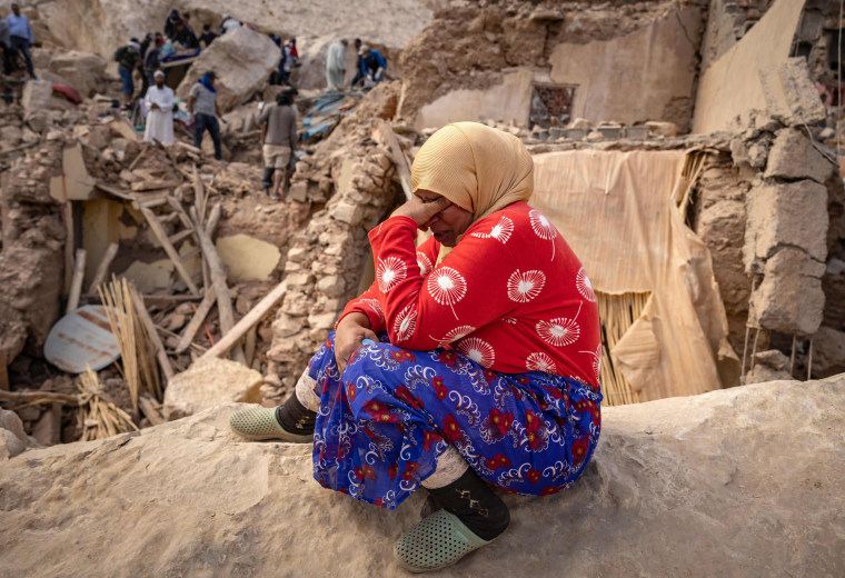 A woman reacts by the rubble of destroyed buildings in Imi N'Tala, Morocco.
