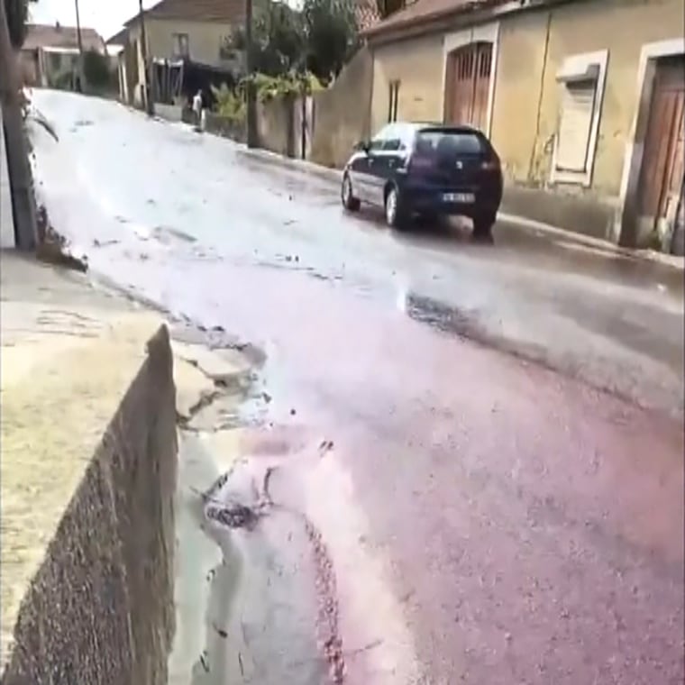 Spilled red wine runs through the streets after two tanks burst in São Lourenço do Bairro, Portugal on Sept. 10, 2023. 