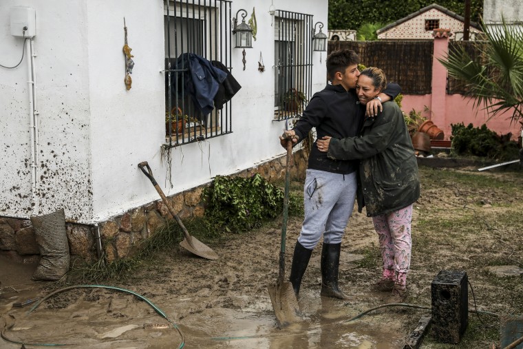 A woman hugs her son as they clear her house from mud following heavy rain in Villamanta, Spain, on Sept. 4, 2023.