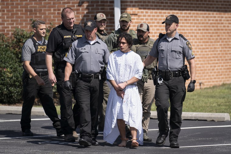 Law enforcement officers escort Danelo Cavalcante from a Pennsylvania State Police barracks