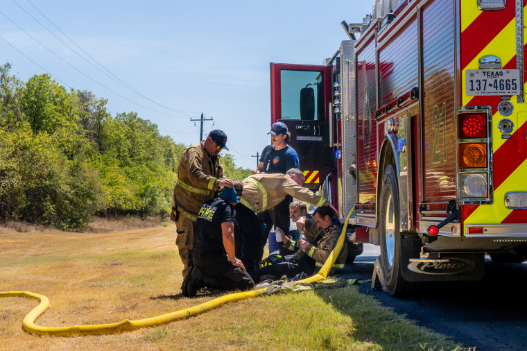IMage: Hays County Emergency Service and Kyle and Buda Fire Departments rest and recover together while battling wildfires during scorching temperatures near Austin on Aug. 8.