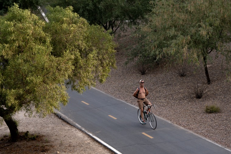 Image: A man rides his bike during a brutal heat wave in Tucson, Ariz., on July 15.