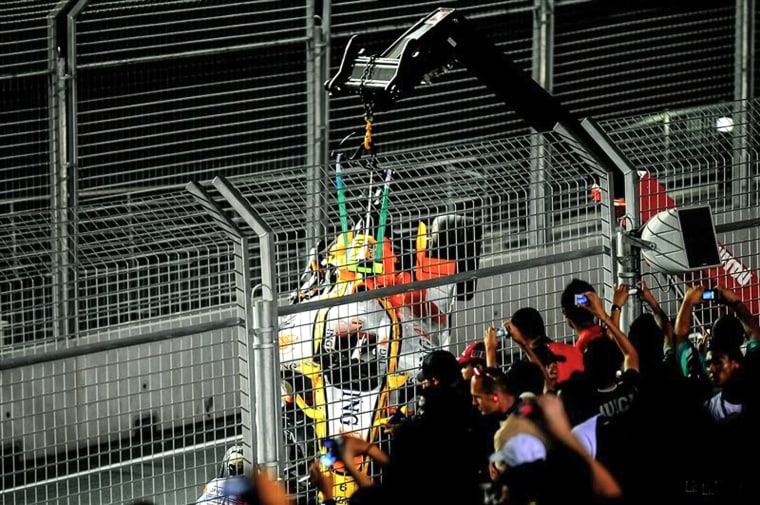Renault Formula One auto racing driver Brazil's Nelson Piquet Jr.'s car is lifted by a crane while fans watch and take pictures at the Singapore Formula One Grand Prix on the Marina Bay City Circuit in Singapore on Sept. 28, 2008.