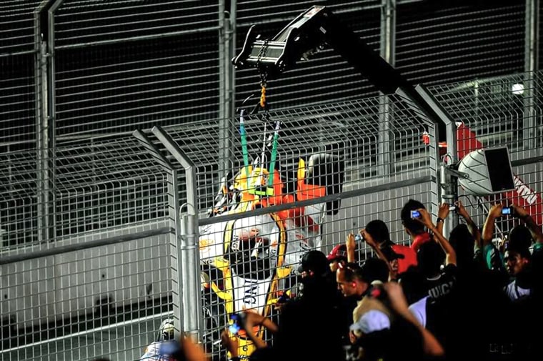 Mobil pembalap mobil Renault Formula Satu asal Brazil Nelson Piquet Jr. diangkat dengan derek saat para penggemar menonton dan mengambil foto selama Grand Prix Formula Satu Singapura di Sirkuit Marina Bay City di Singapura pada 28 September 2008 .