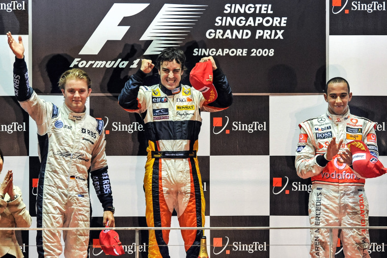 Spanish driver Fernando Alonso of Renault celebrates with third-placed British driver Lewis Hamilton of McLaren and second-placed German driver Nico Rosberg of Williams on the podium after Alonso's victory in the Formula One Singapore Grand Prix final September 28, 2008.