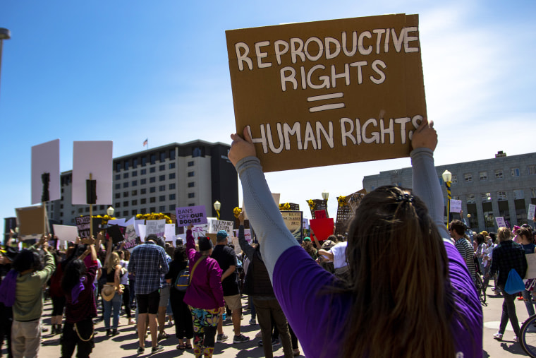 A protester holds a placard up that says "Reproductive rights = Human rights". Protestors gathered to voice their anger at the leaked Supreme Court documents.