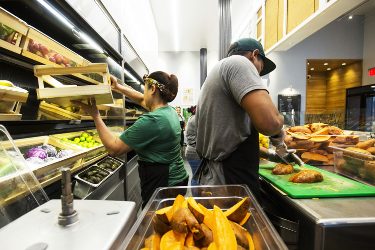 Workers prepare food inside a Sweetgreen
