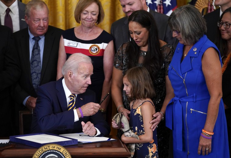 Image: President Joe Biden, after signing the PACT Act of 2022, gifts his pen to Brielle Robinson, the daughter of Sgt. 1st Class Heath Robinson, who died of cancer two years prior.