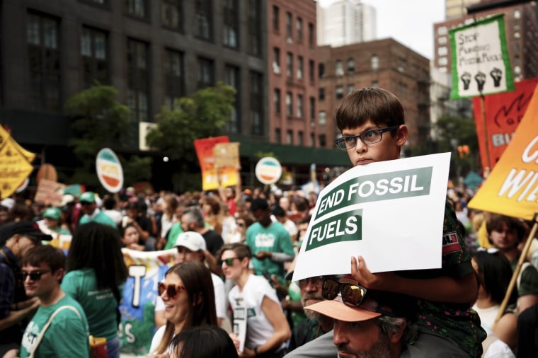 A boy listens to a speaker during a rally to end the use of fossil fuels in New York
